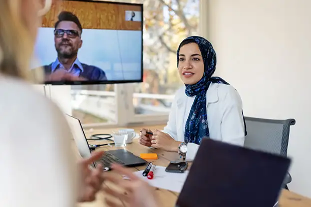 A woman in a headscarf is talking to a man on a video call