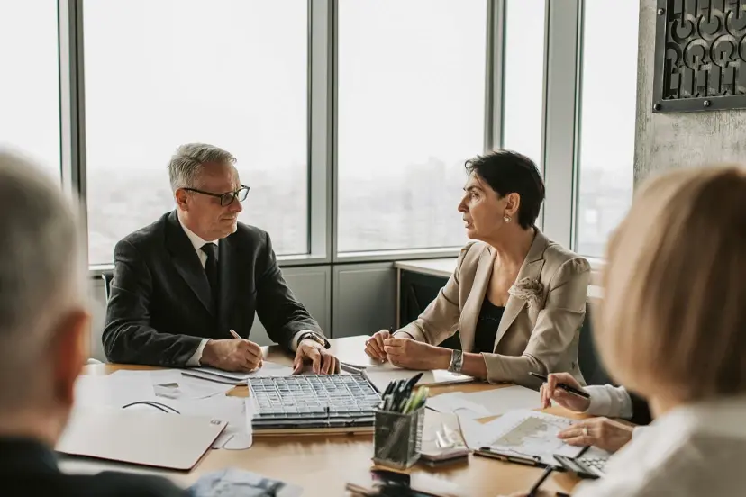 A group of people sitting around a table talking during a business meeting