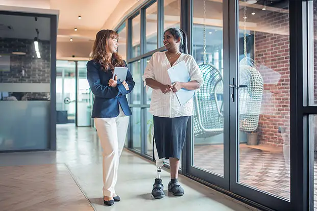 2 women walking down a hall talking